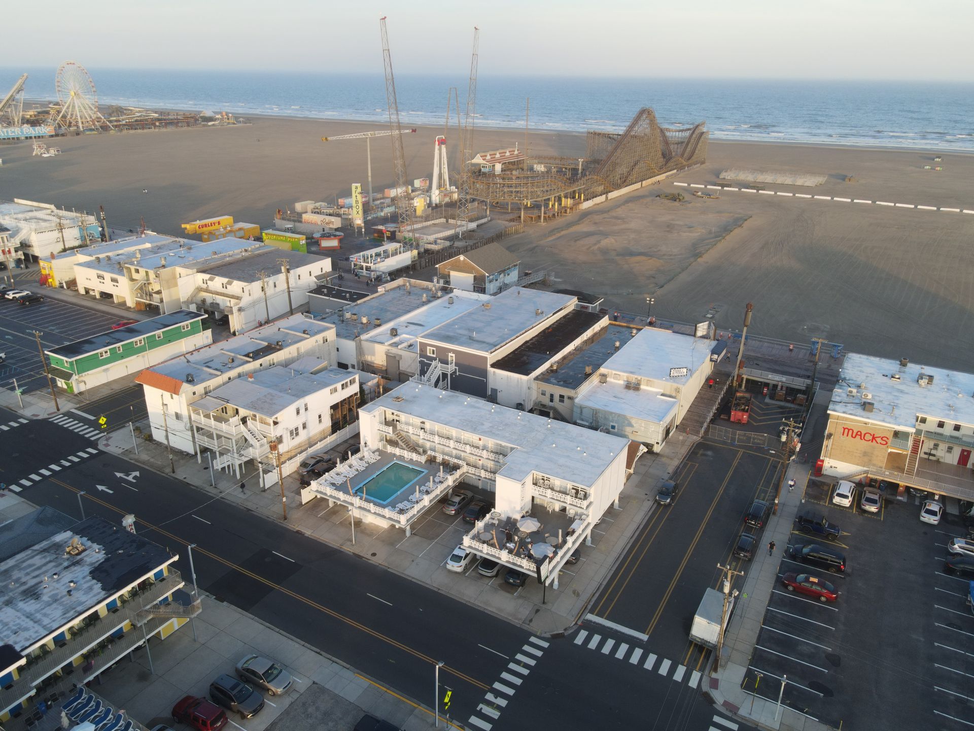 An aerial view of a beach resort with a roller coaster in the background.