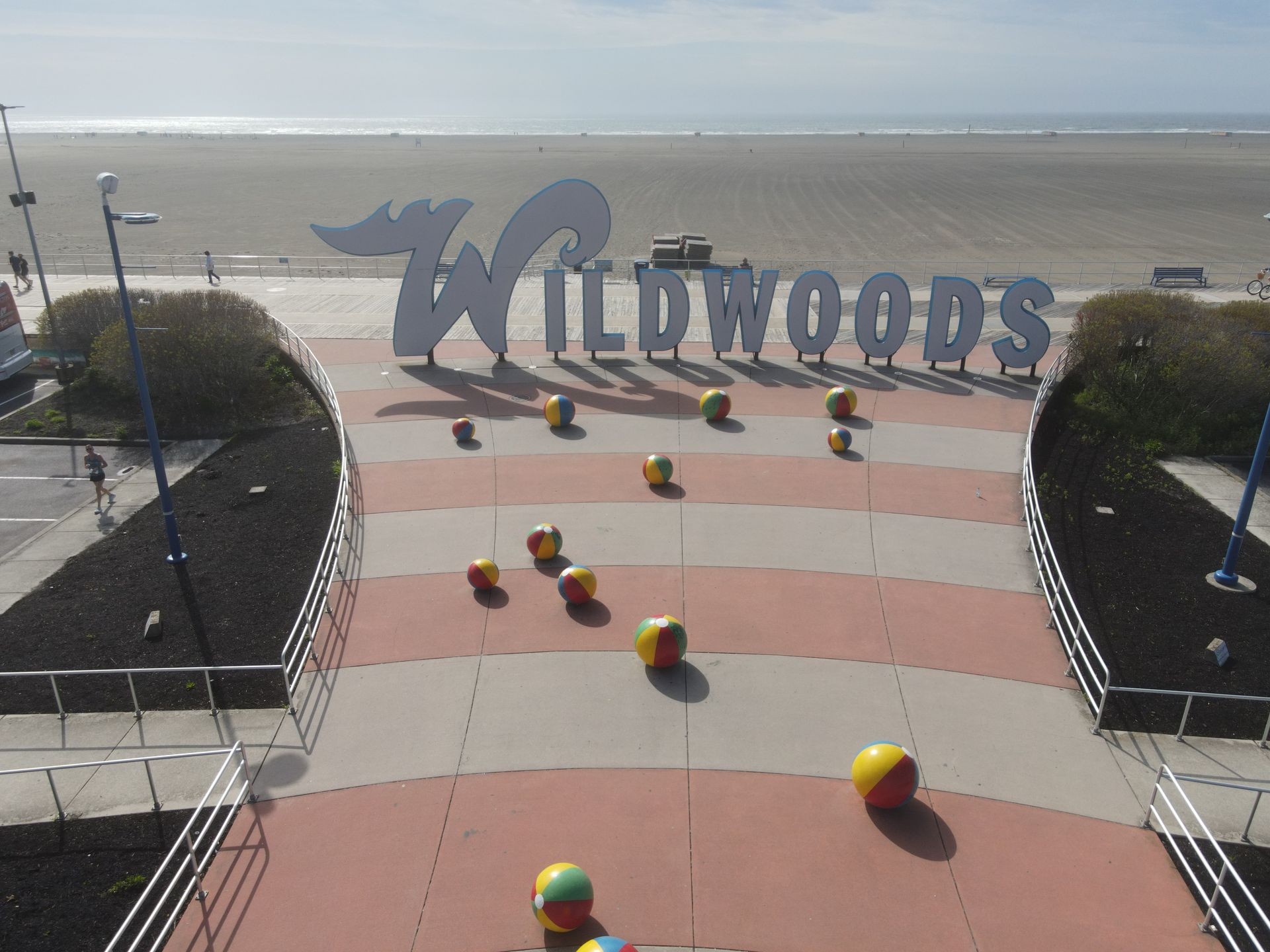 A sign that says wildwoods on it in front of a beach