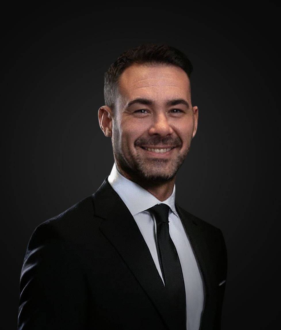 En mann sitter på en sofa og snakker med en annen mann.