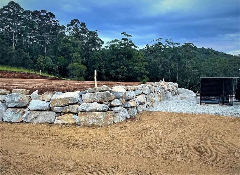 Stone Retaining Wall With a Gravel Driveway — Blue Dog Earthmoving Landscape Supplies in Bellingen, NSW