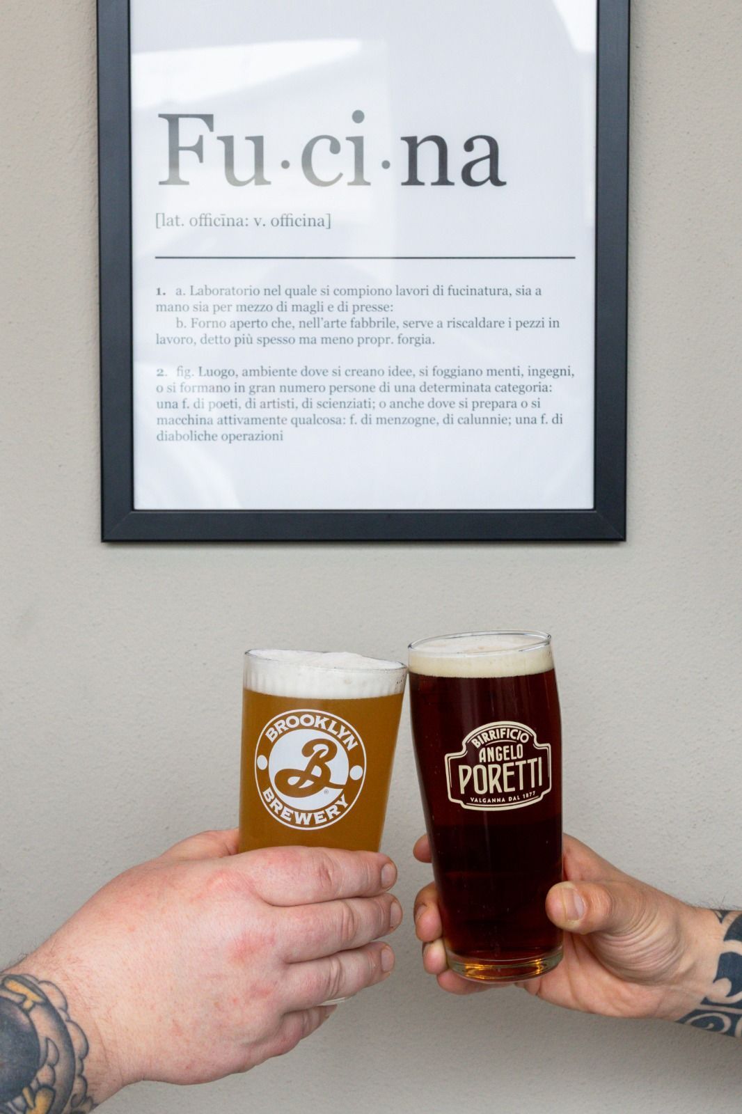 Un gruppo di persone è seduto a un tavolo e beve birra e mangia hamburger.