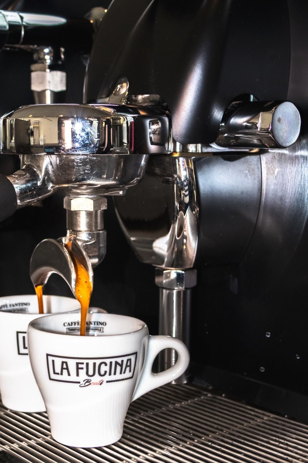 Una persona tiene in mano un piatto nero con un hamburger sopra.