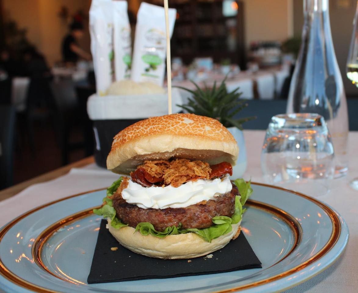 Un piatto blu con un hamburger sopra