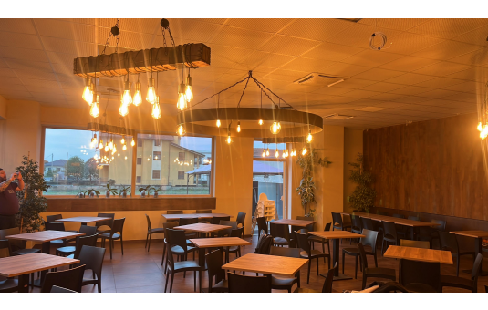 Un ristorante con tavoli e sedie e un lampadario appeso al soffitto.