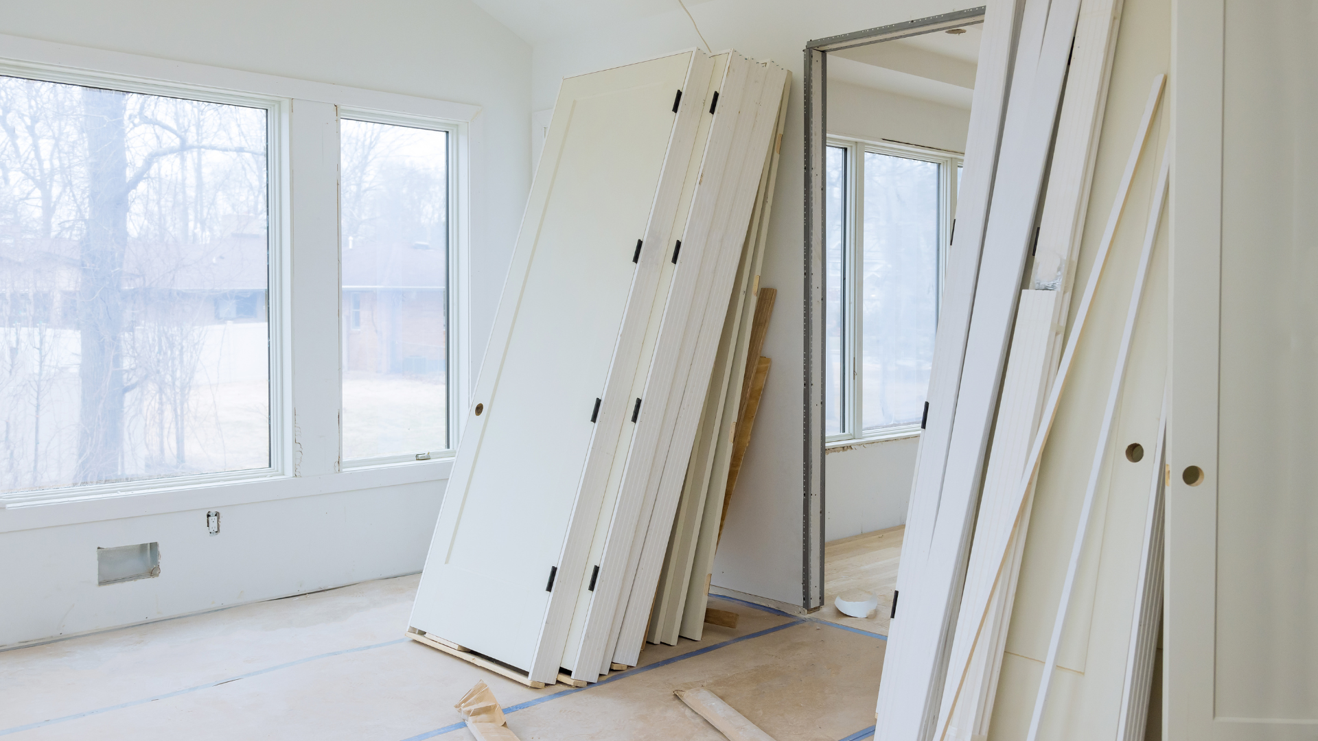 A room with a lot of white doors stacked on top of each other.