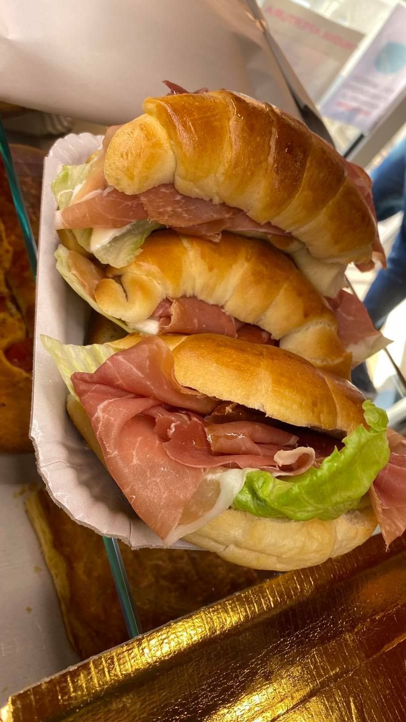 Tre panini sono impilati uno sopra l'altro su un piatto di carta.