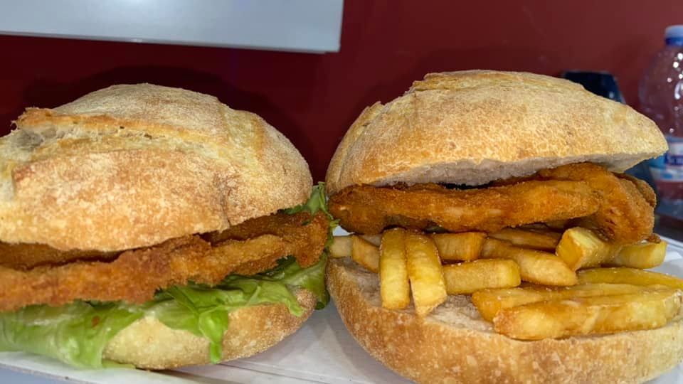Due panini con patatine fritte su un piatto su un tavolo.