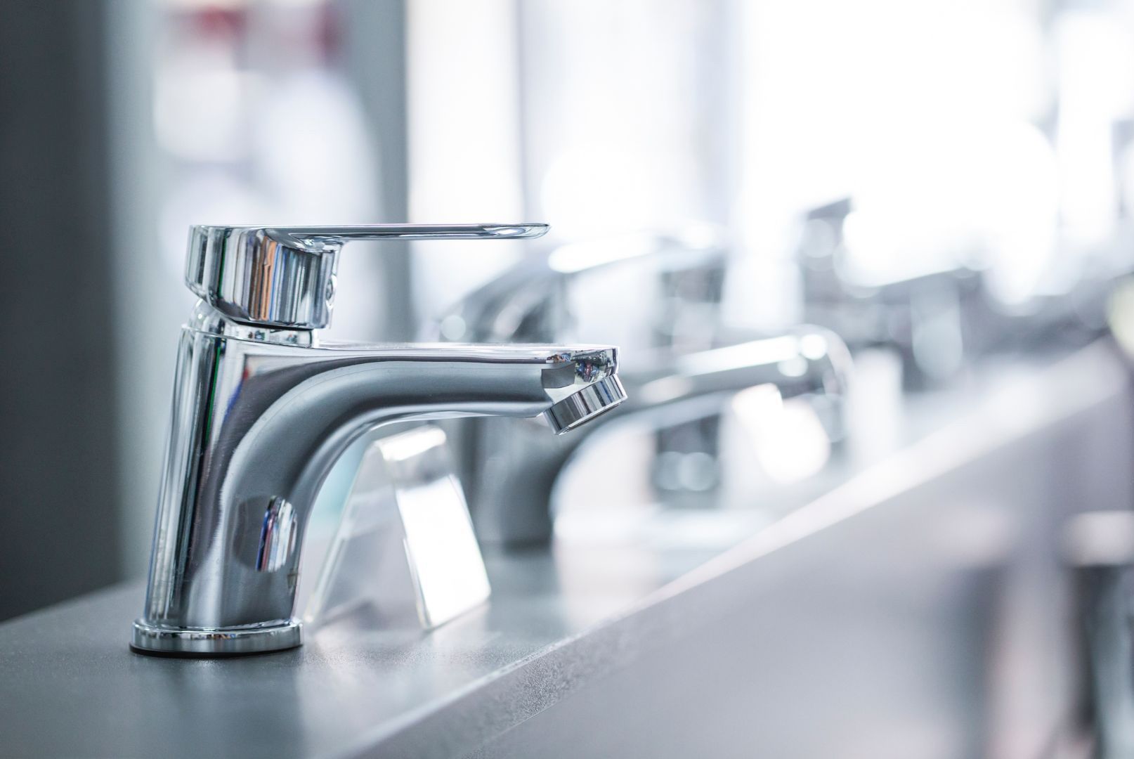 A close up of a faucet on a counter in a bathroom.