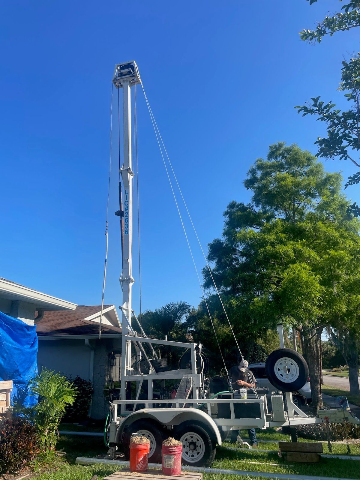 A large crane is sitting on top of a trailer in front of a house.
