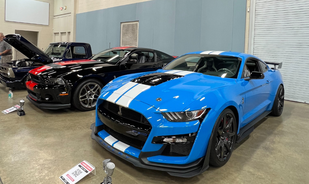 Front view of bright blue Shelby sports car with white hood stripes