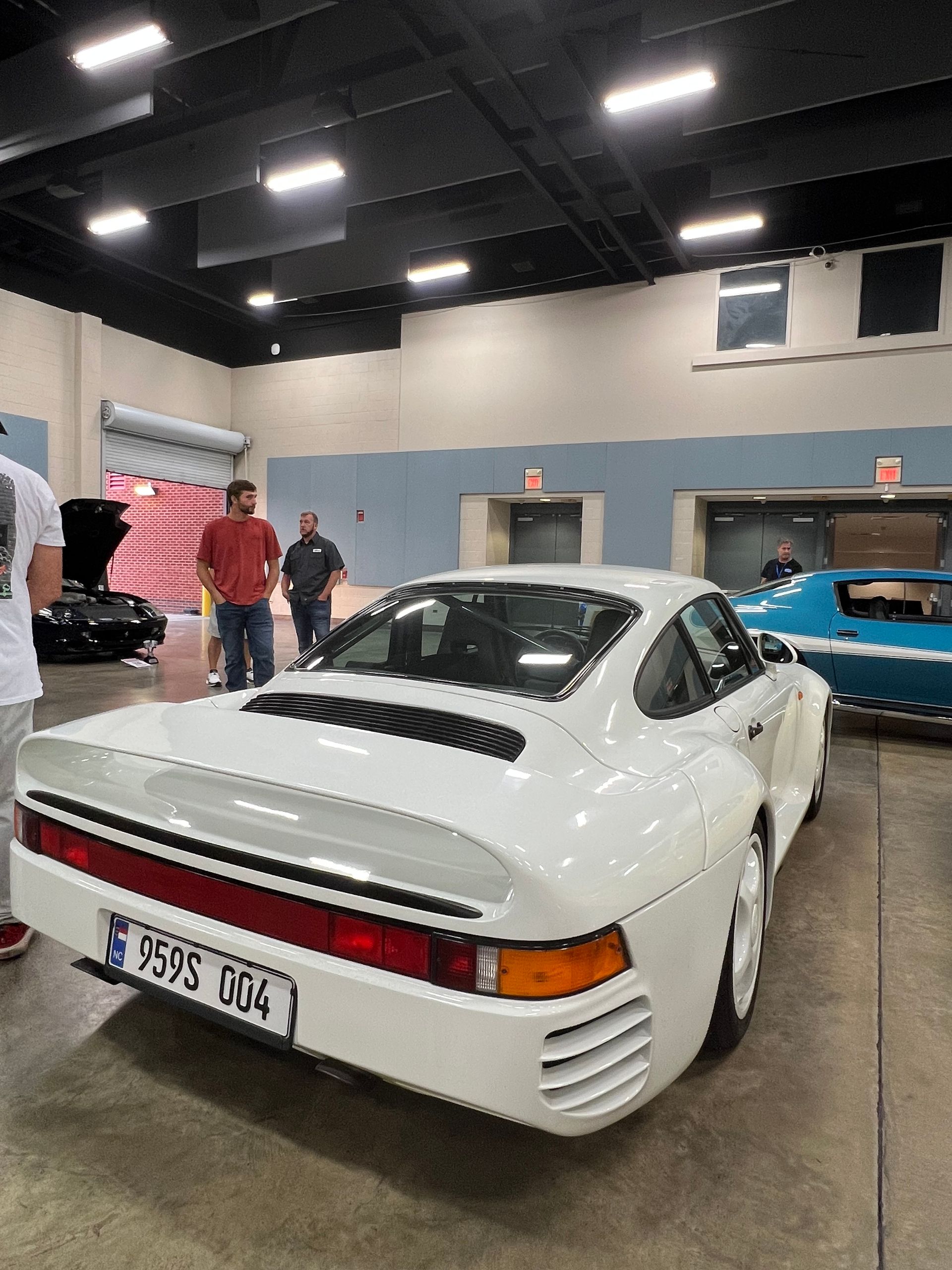 Men looking at white sports car