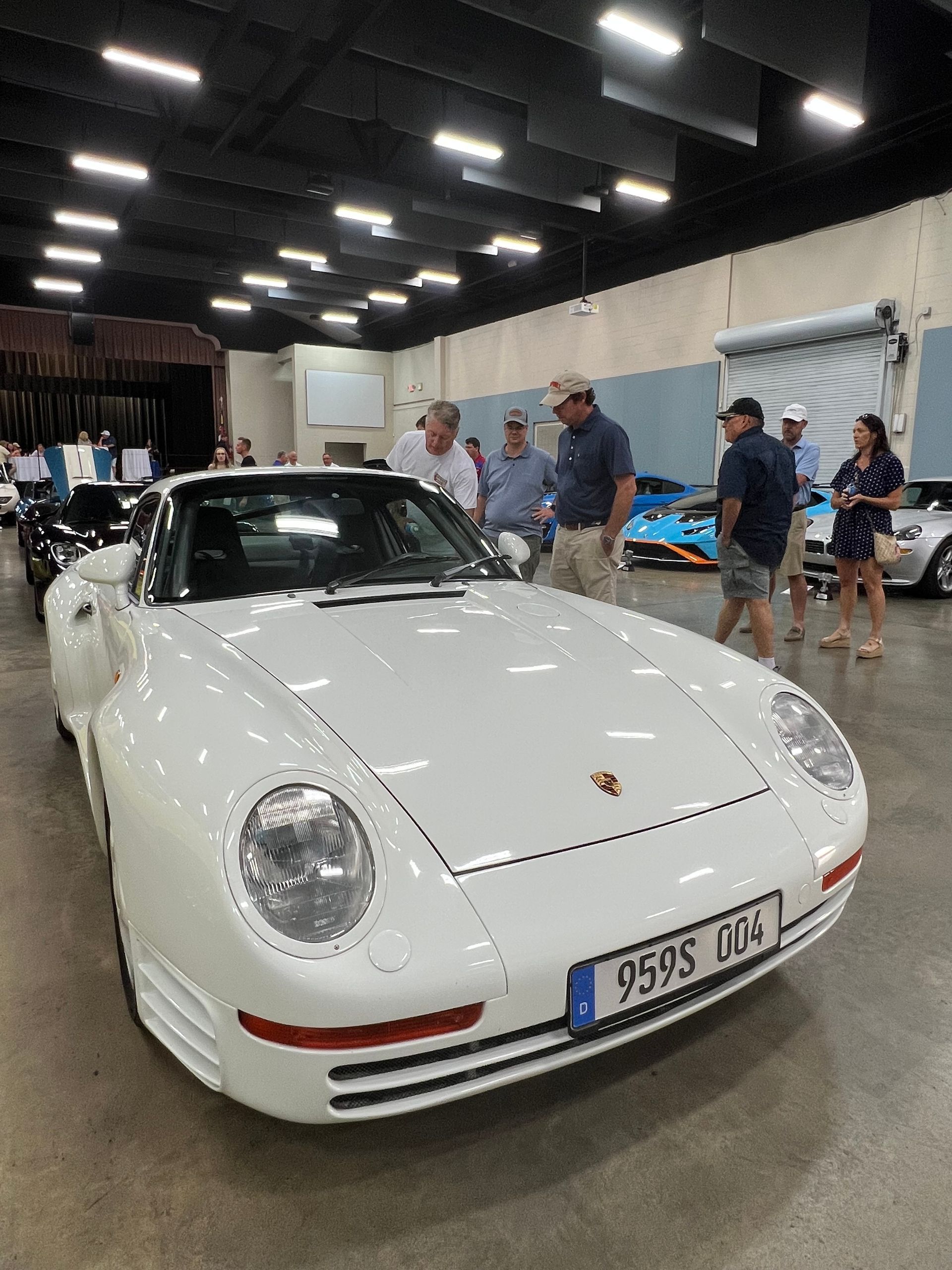 Men looking at white sports car
