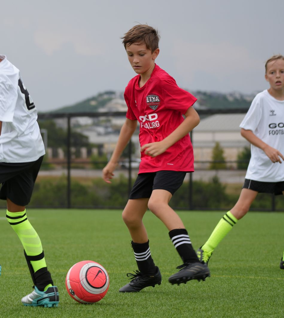Three youth soccer players for Lake Travis Football Club