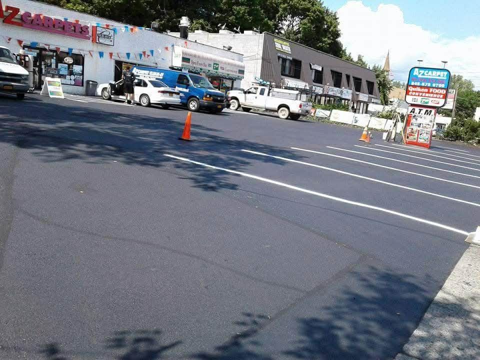 Paved road with yellow lines, parking spaces, and sidewalks.