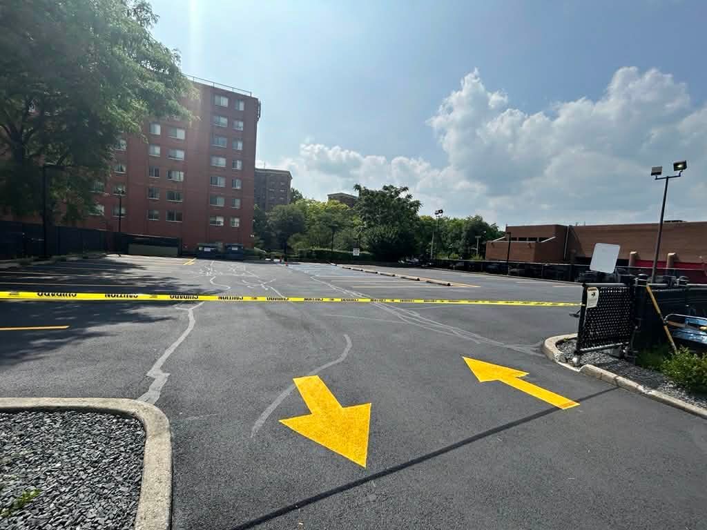 Road paving in progress. Asphalt paving machine, workers, and roller on a residential street.