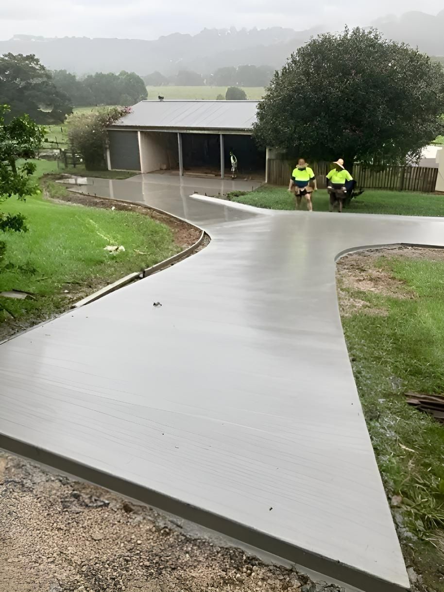 Wet Concrete Driveway With Two Workers — Northern Rivers Concrete Construction in Pimlico, NSW