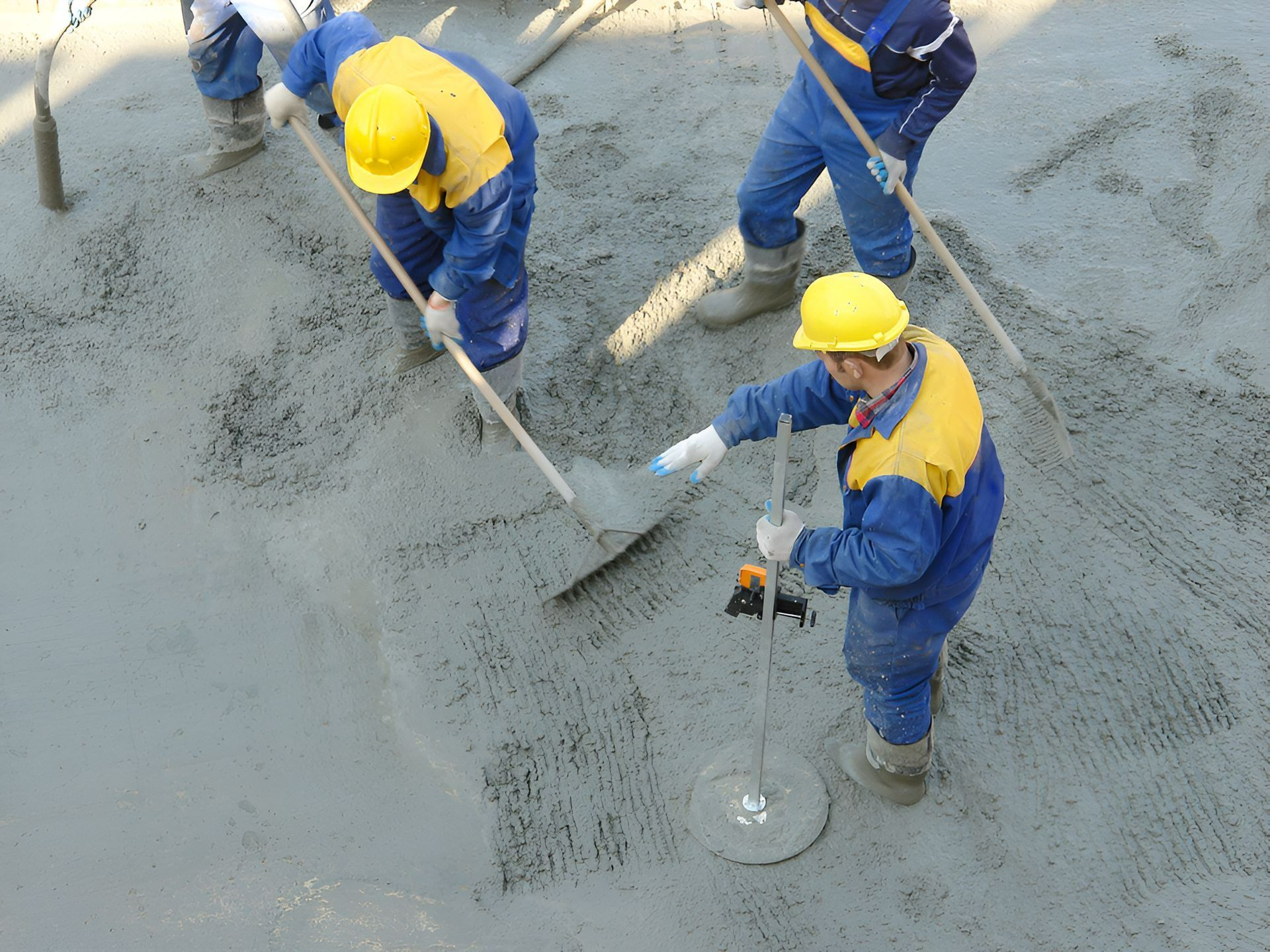 Construction Workers in Blue Uniforms and Yellow Hard Hats — Northern Rivers Concrete Construction in Ballina, NSW