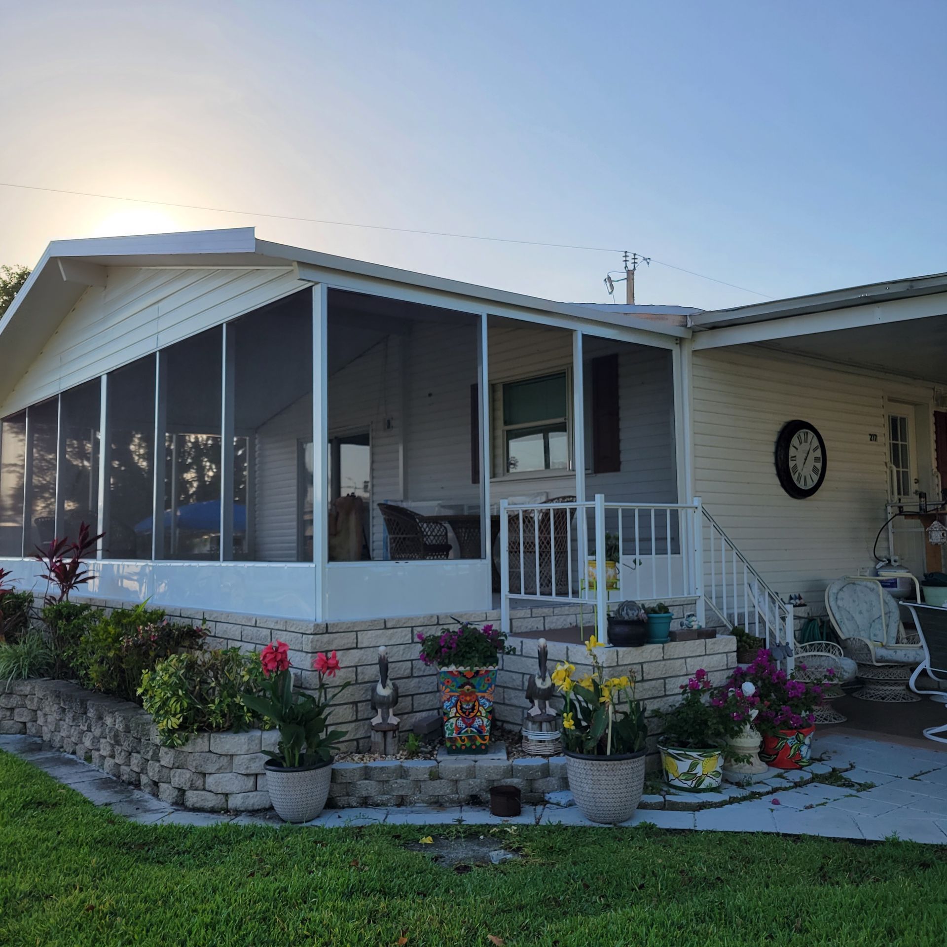 A house with a screened in porch and a clock on the wall