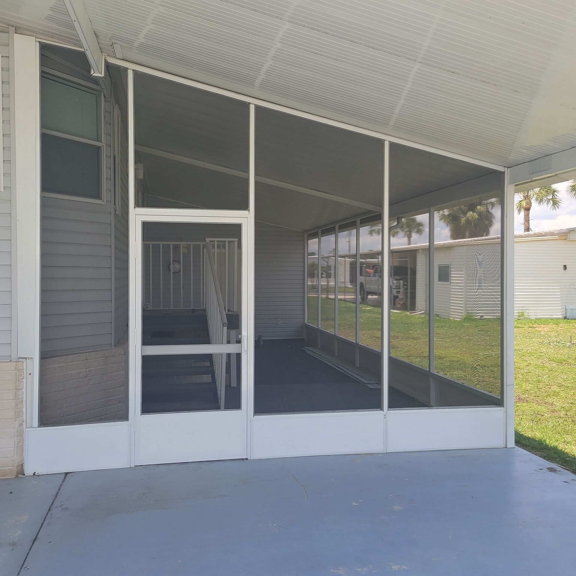 A screened in porch with a staircase leading up to it.