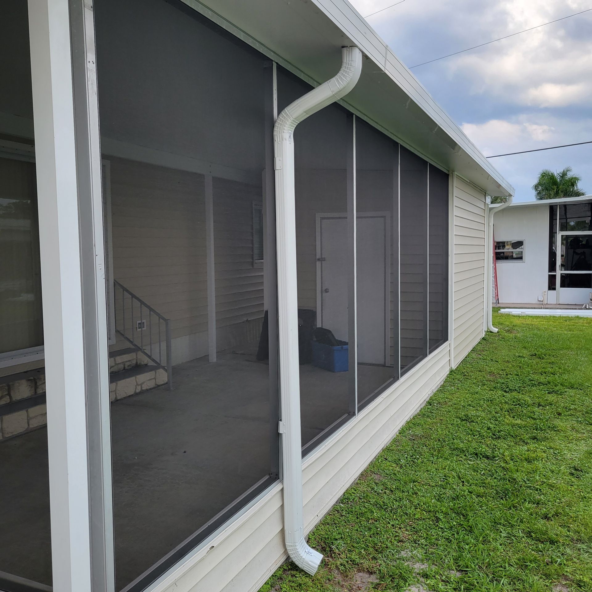A house with a screened in porch and a drainpipe