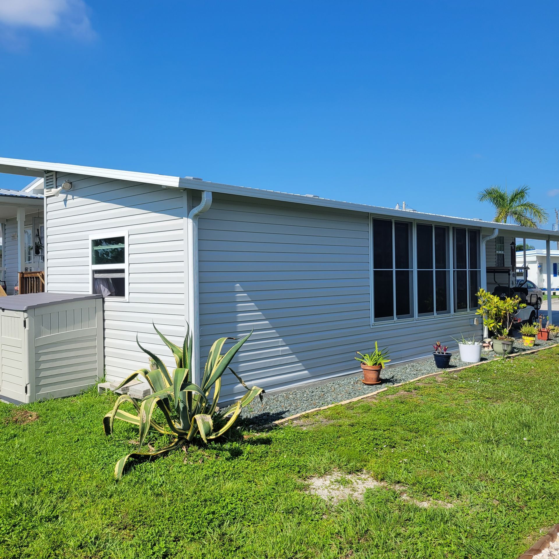 A white mobile home is sitting on top of a lush green lawn.