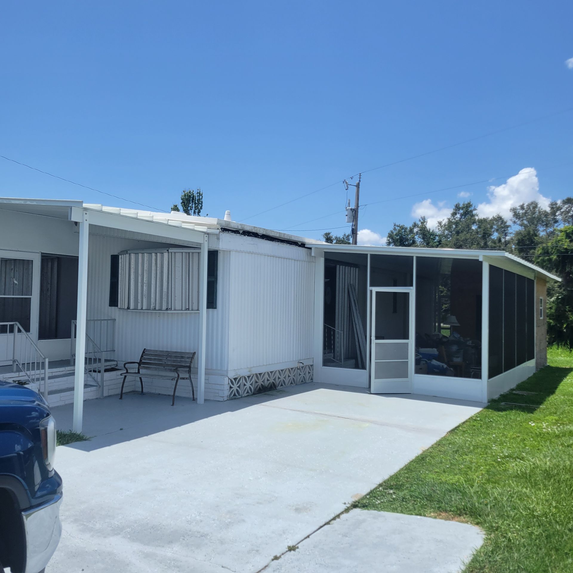 A blue truck is parked in front of a mobile home