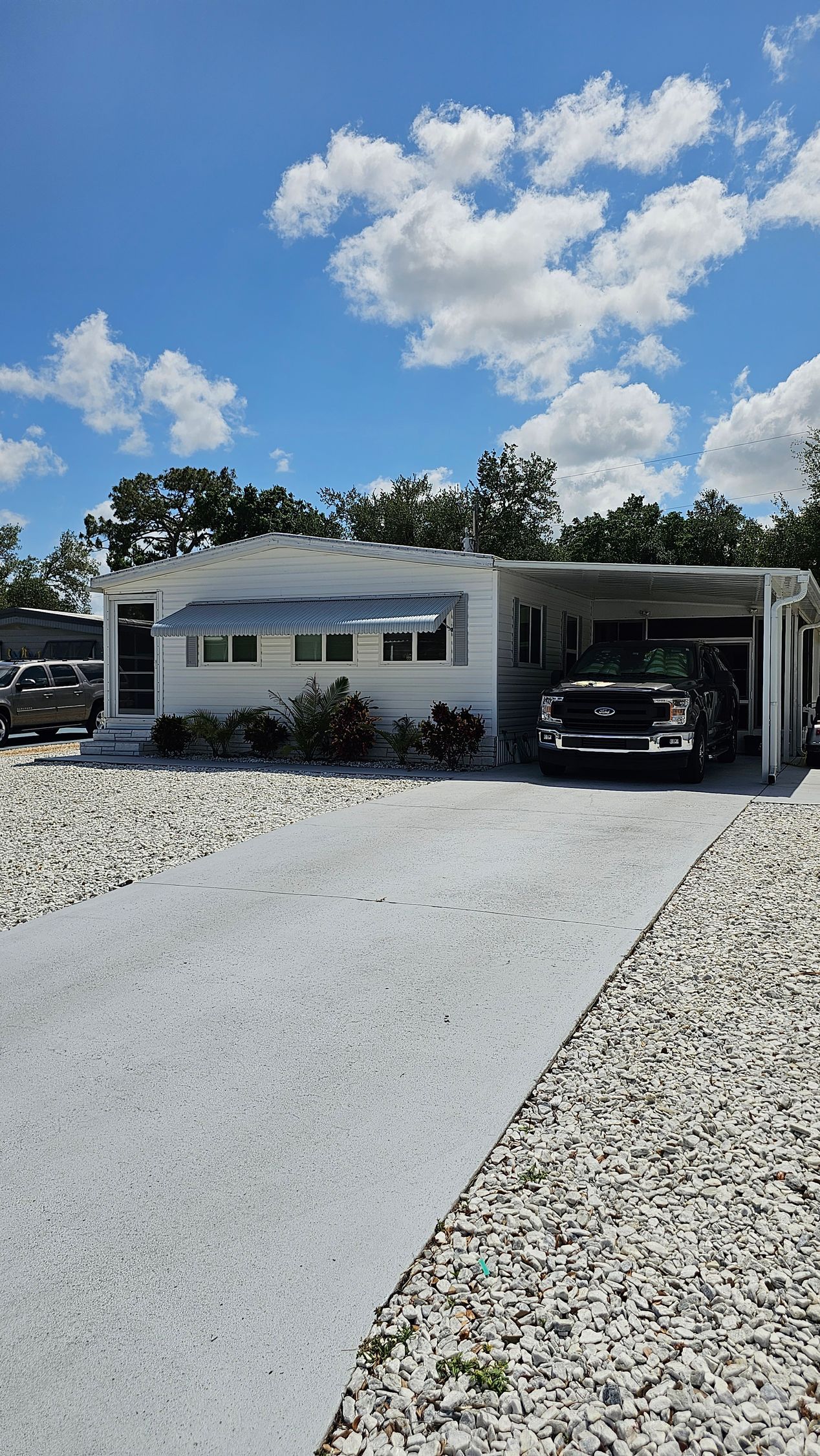 A white house with a black truck parked in front of it.