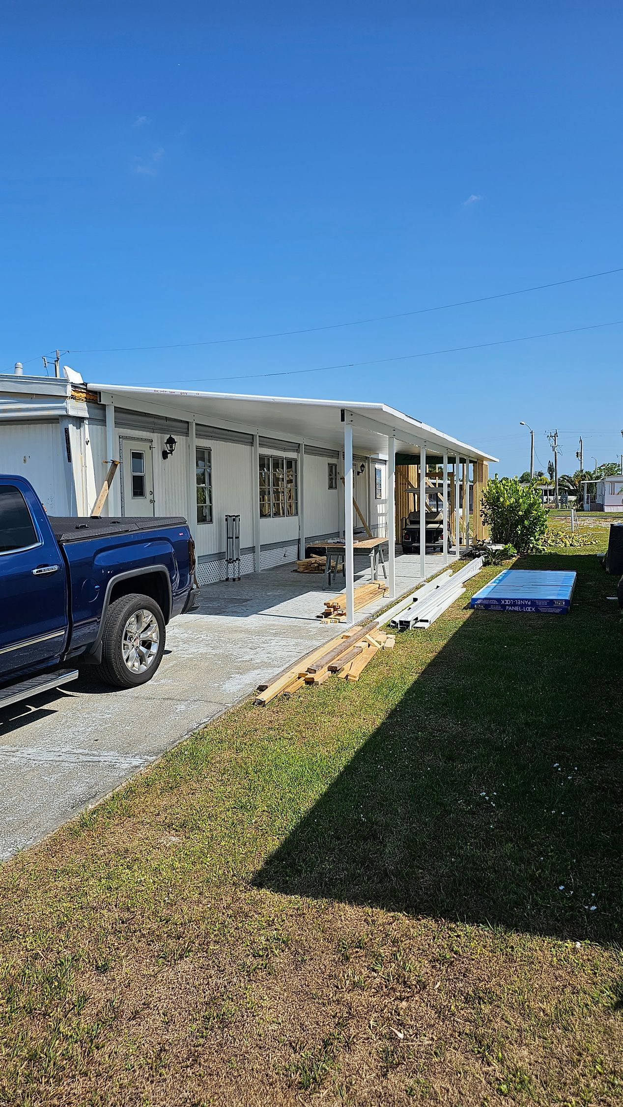 A blue truck is parked in front of a mobile home.