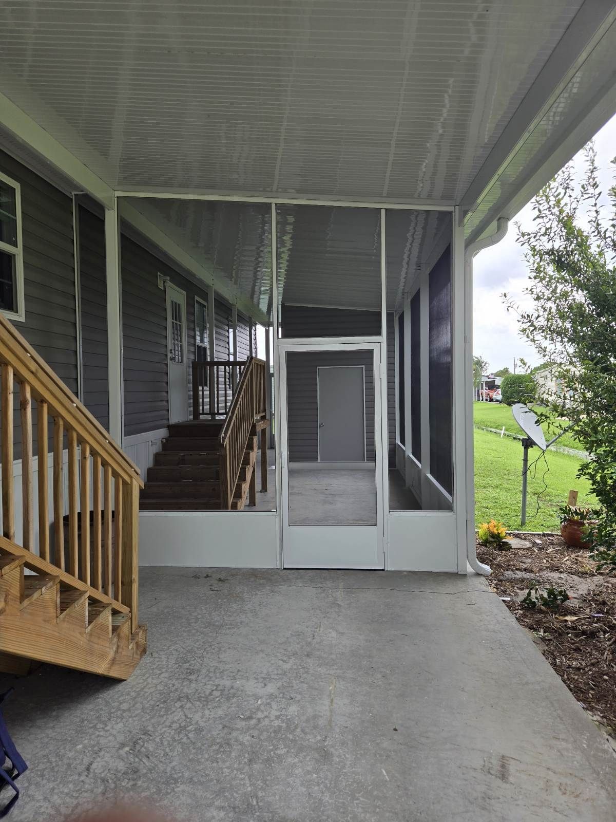 There is a screened in porch with stairs leading up to it.