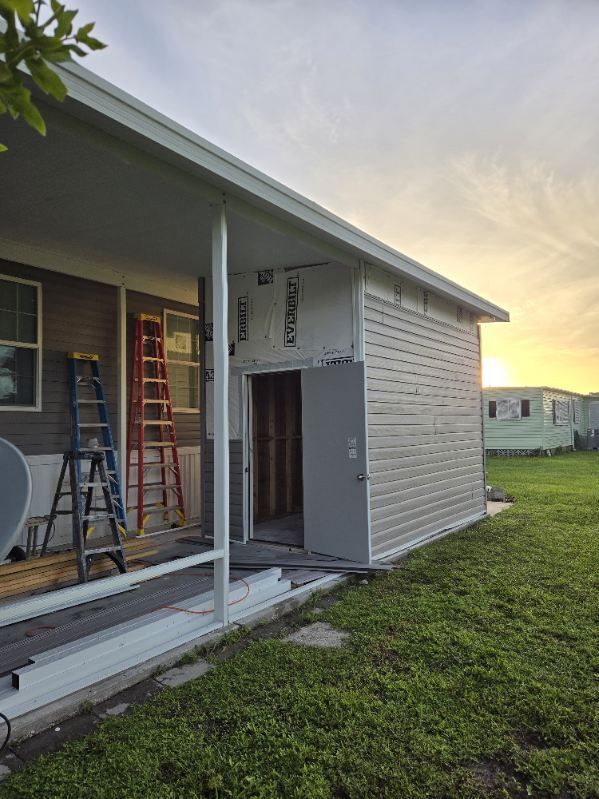 A mobile home with a shed being built on the side of it.