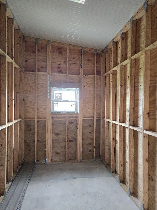 An empty room with wooden walls and a window.