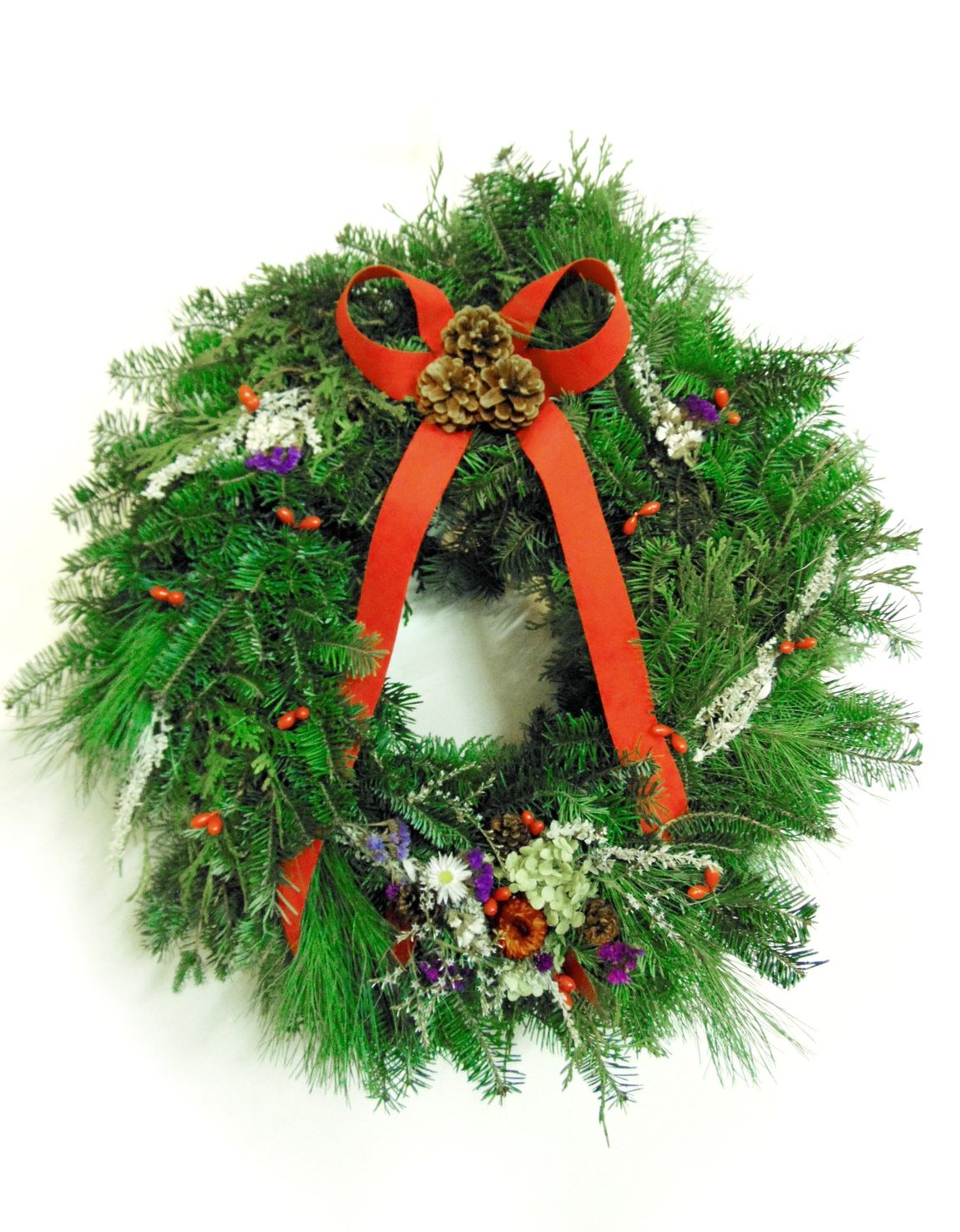 Vermont hand crafted wreaths with white, purple, and red flowers, white sprigs, and red ribbons