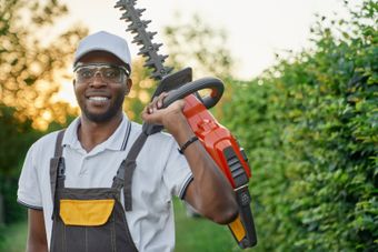 A picture of a lawn care professional with a hedge trimmer.