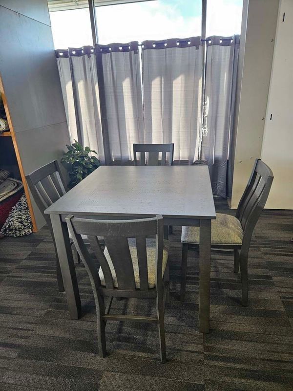 Gray dining table and chairs in front of a window with gray curtains; carpeted floor.