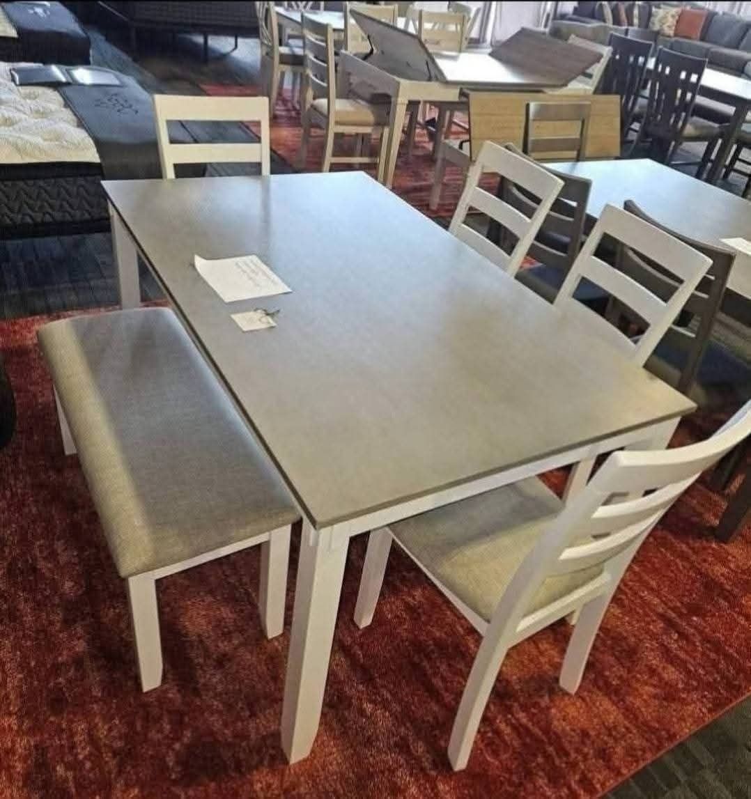 Modern kitchen with white cabinets, island with stools, and stainless steel appliances.