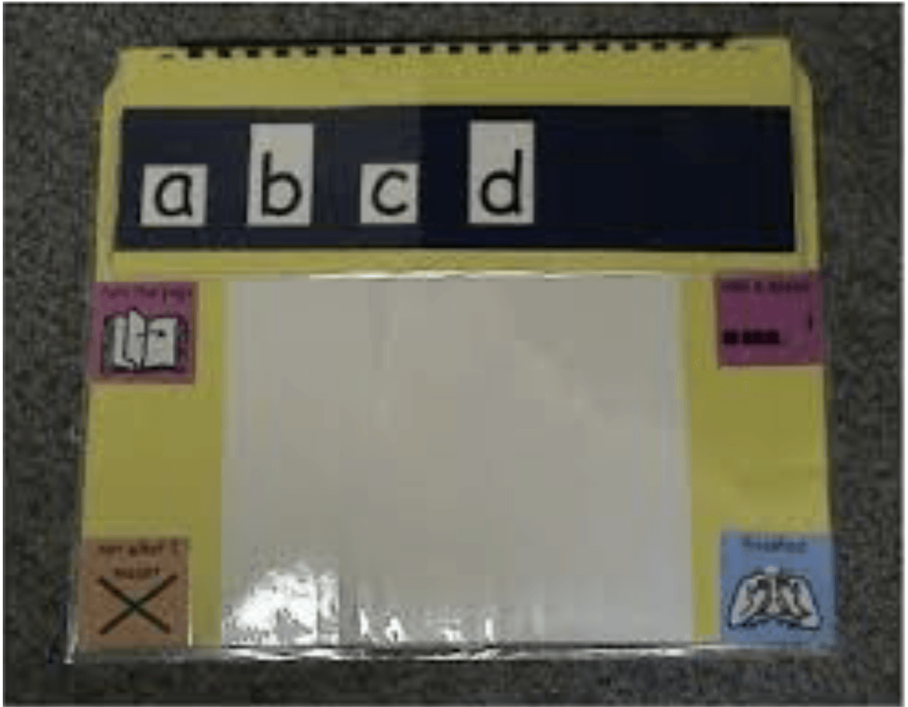 ABCD is displayed on a black strip of construction paper that is on top of yellow construction paper. 