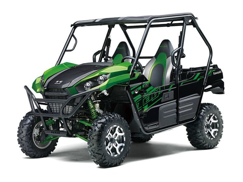 Green and black Kawasaki Teryx side-by-side off-road vehicle with roll cage and large tires.