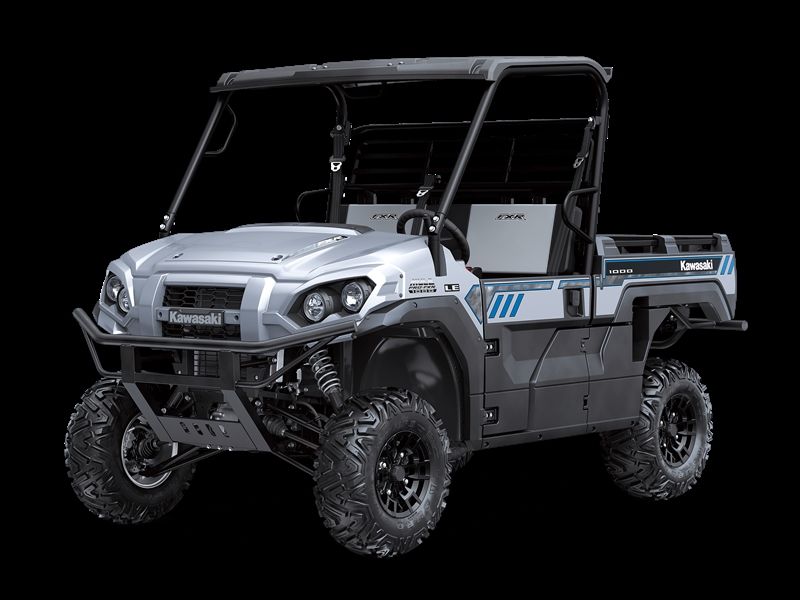 Silver Kawasaki Mule side-by-side utility vehicle with black wheels and roll cage against a black background.
