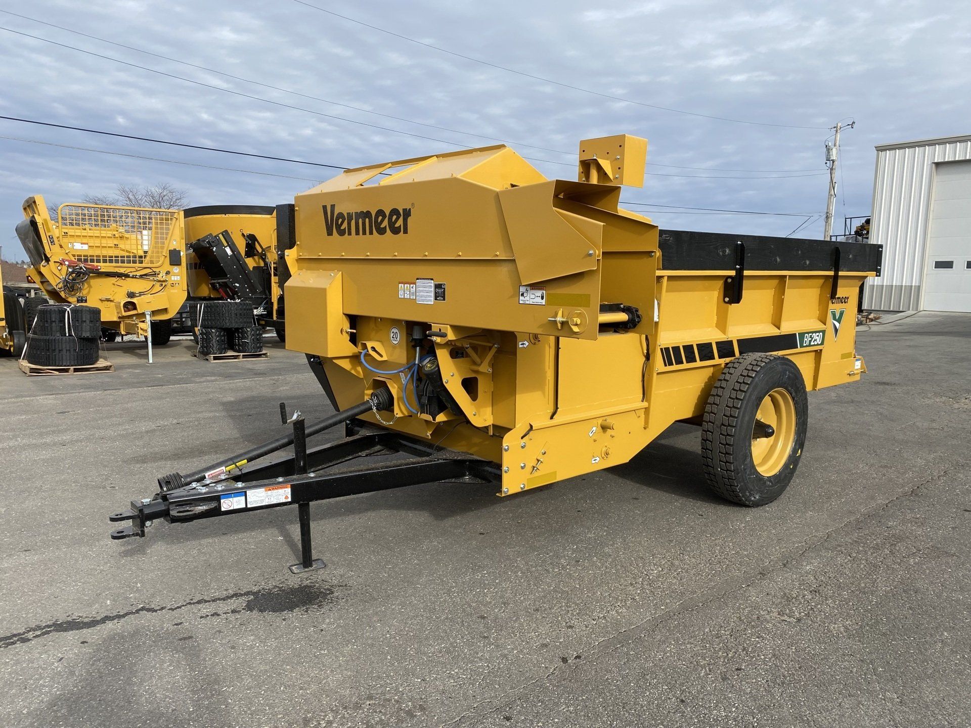 Yellow Vermeer compost turner trailer parked outside.