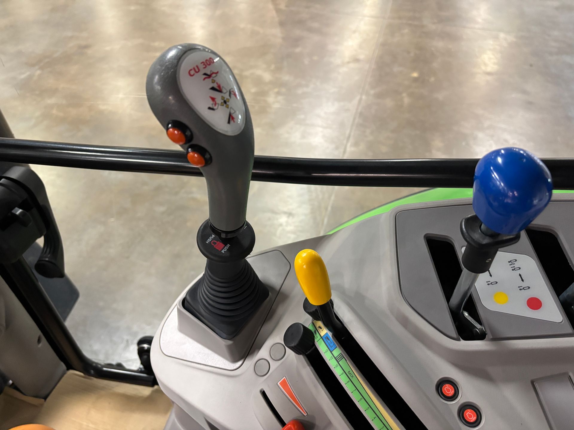 Tractor control panel, gray joystick with buttons, blue and yellow levers.