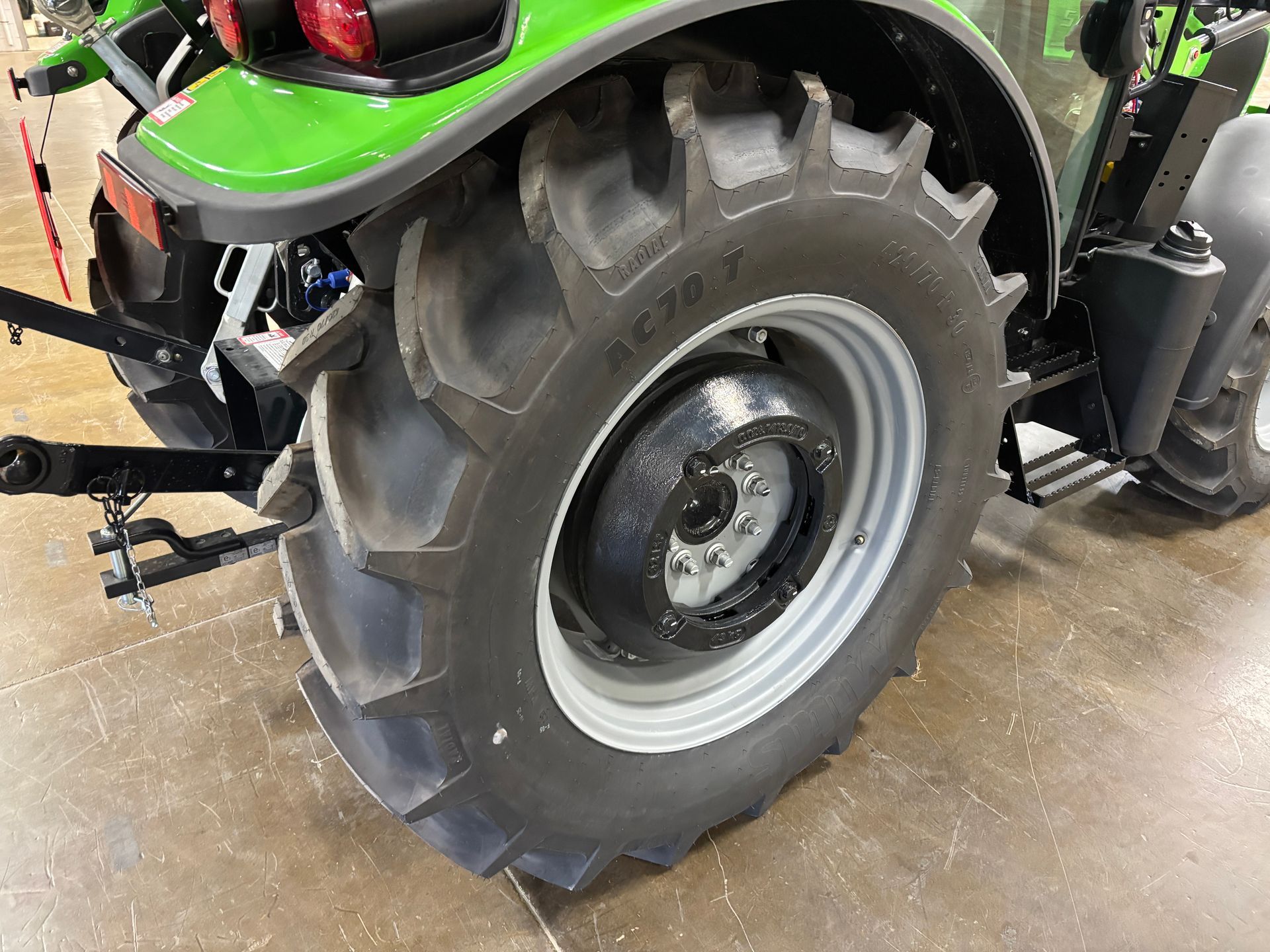 Green tractor rear tire on gray rim, treads visible.