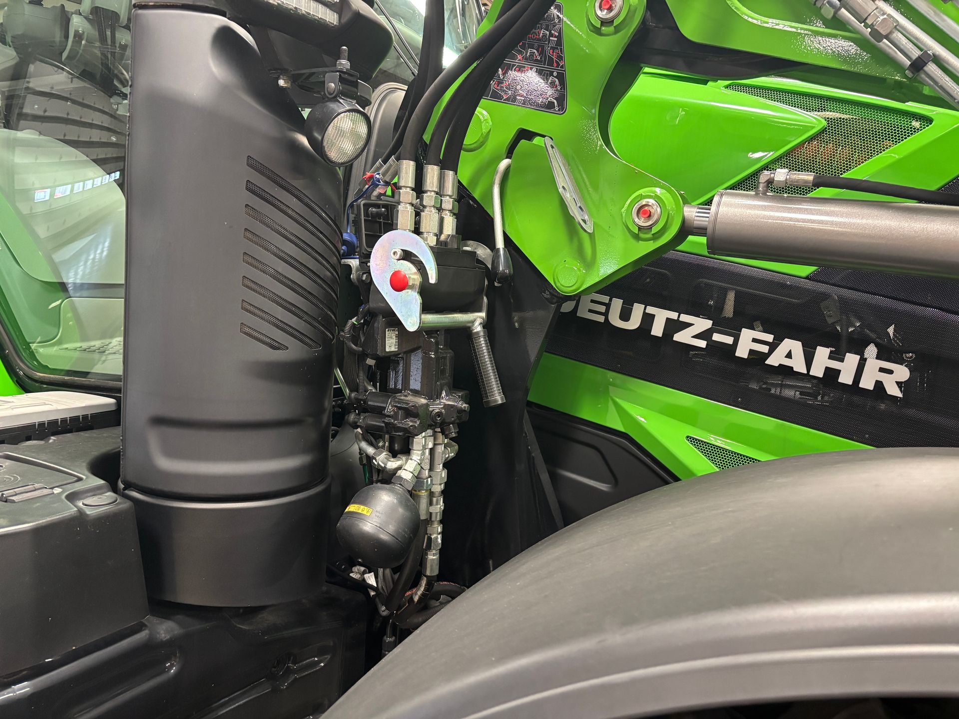 Close-up of a green and black Deutz-Fahr tractor interior, showing hydraulic components and details.