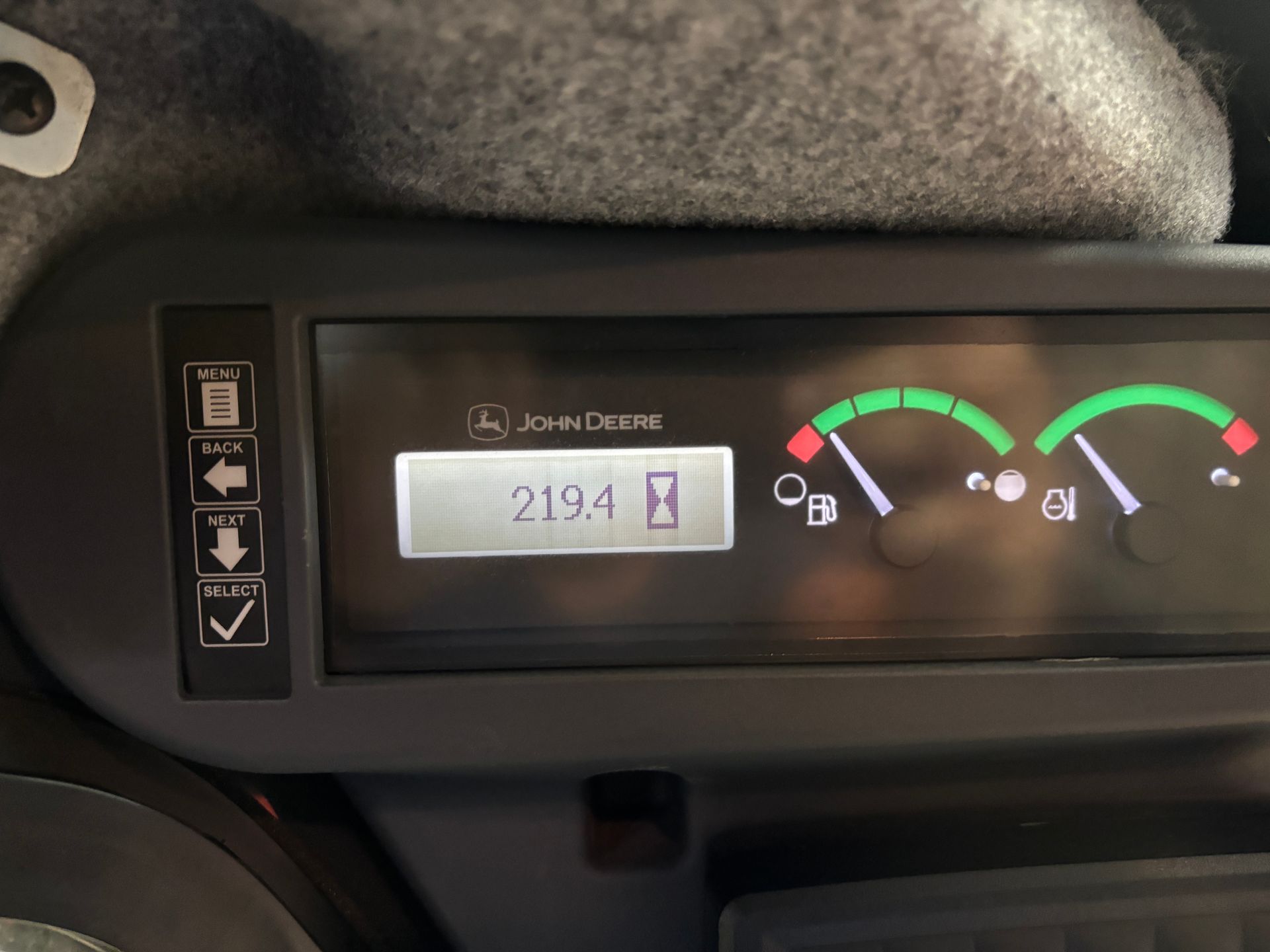 Dashboard with John Deere logo, displaying hours (219.4), fuel and other gauges.