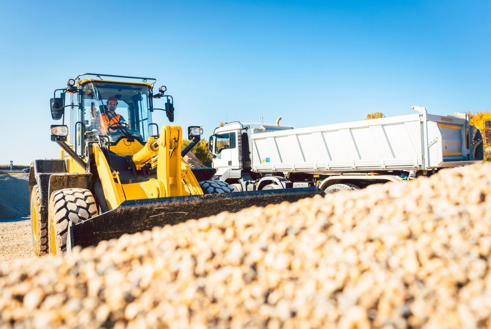 A Construction Vehicle With a Bulldozer Parked in Front of a Truck — Koumala Quarry In Koumala, QLD
