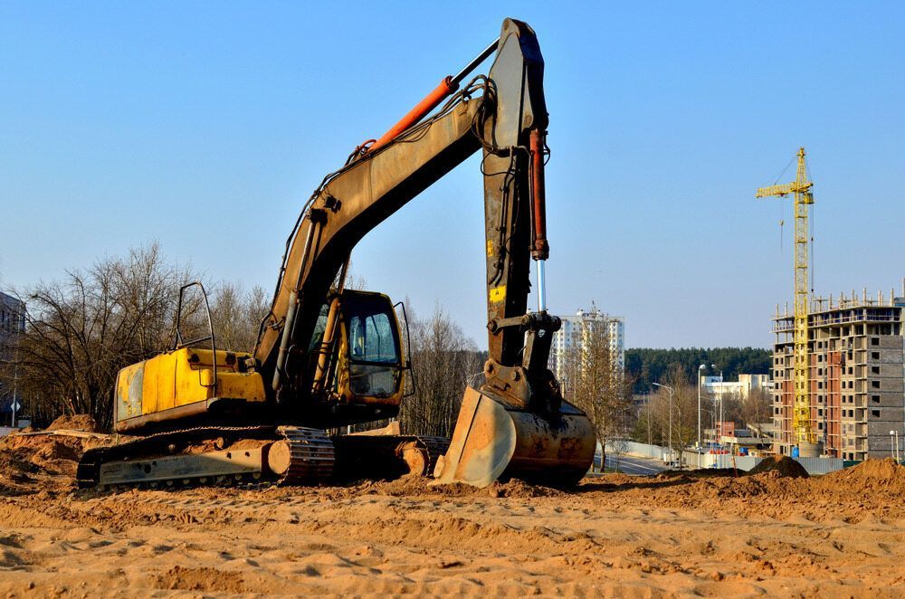 A Large Yellow Excavator is Sitting on Top of a Dirt Field — Koumala Quarry In Nebo, QLD