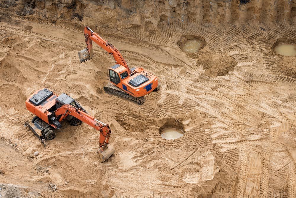 Two Excavators Are Working in a Dirt Ground — Koumala Quarry In Koumala, QLD
