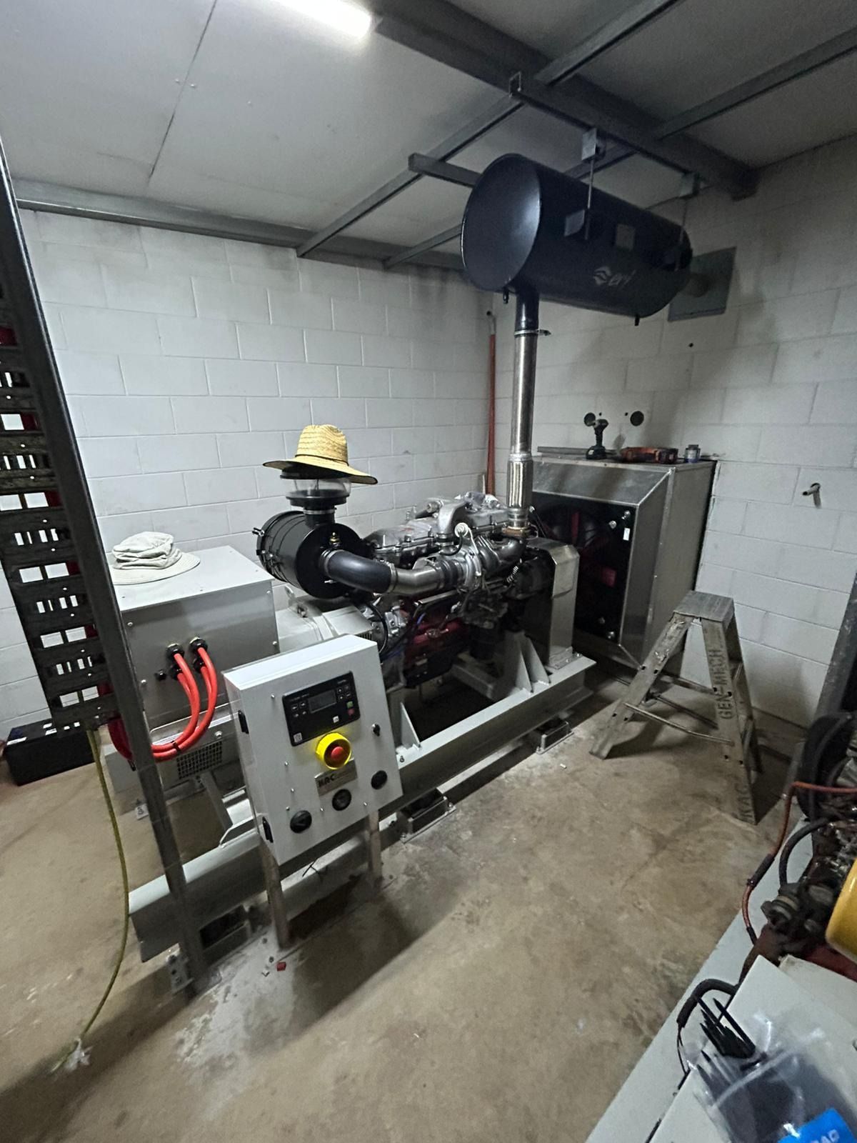 Worker in Hard Hat and Safety Glasses Examines Control Panel — KAC Generation & Mechanical Pty Ltd In Bungalow, QLD