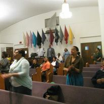 a group of people are standing in a church .