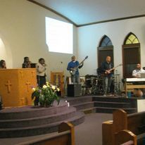 a group of people are playing instruments in a church .