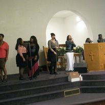 a group of women are singing into microphones in a church .